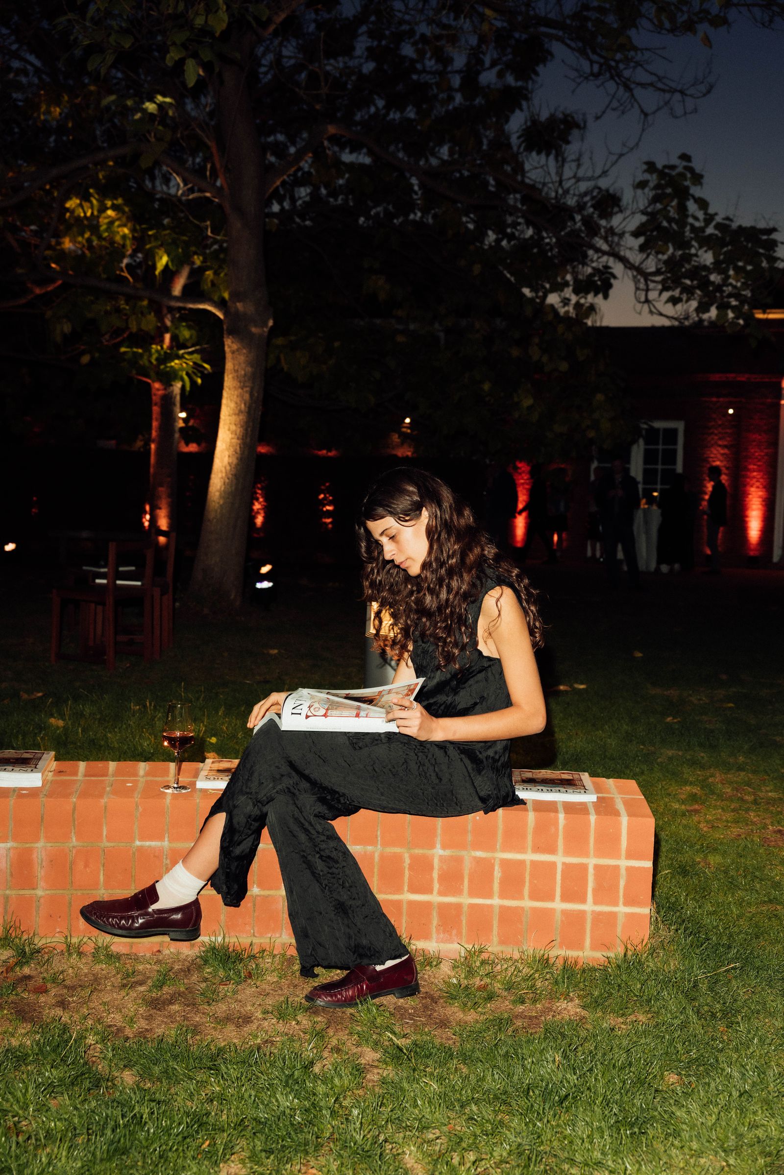 Image may contain Person Sitting Reading Clothing Pants Face Head Photography Portrait Teen Footwear and Shoe